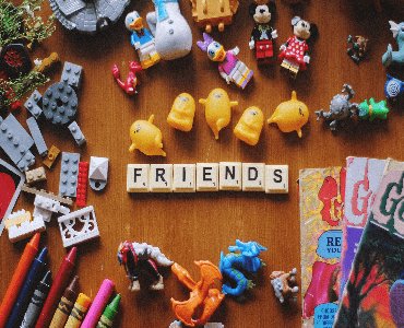 Table top with multiple toys and scrabble bricks spelling the word friends